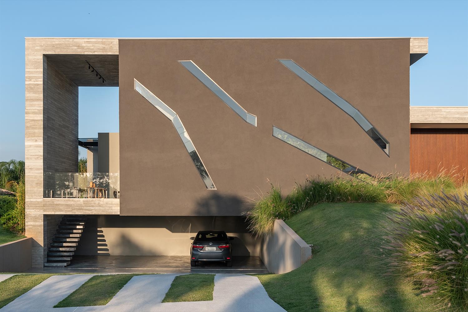 Fachada de casa contemporânea com cores sóbrias, volumetria e